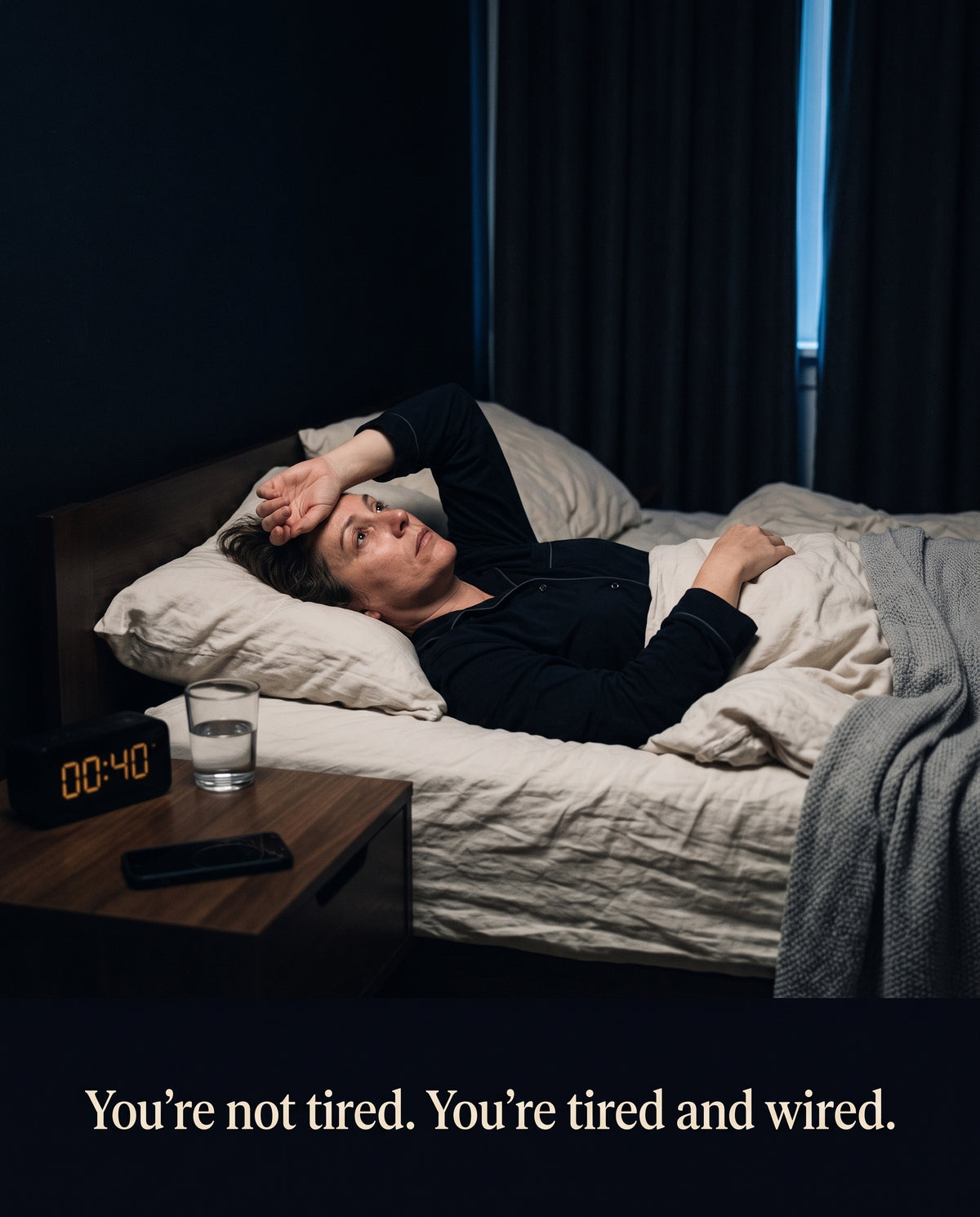 Exhausted person lying awake in bed at night